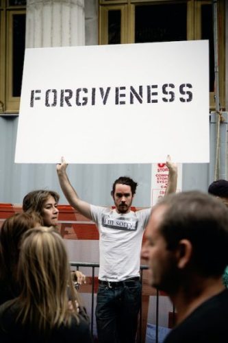 I'm sorry (man holding white sign that says FORGIVENESS) - Pardon Day - September holidays blog post