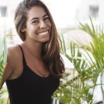 Carefree lovely tanned young woman standing balcony near green plant smiling laughing out loud look adorable grin camera talking casually coworker veranda, enjoy perfect sunny summer days - affordable self-care solutions blog post