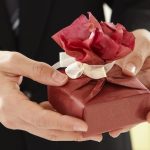 a close-up of a man holding a present