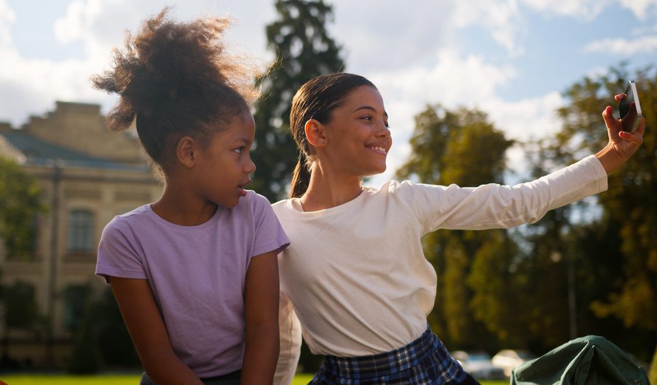 School study elementary education outdoors photo video vlog selfie posing happy little girls classmates students kids children female schoolgirls multiethnic African pupils using phone addicted blog — Call Recording and Kids blog post - two kids taking a selfie